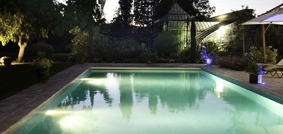 La piscina privada de las casas del Castillo de la Vernède por la noche, alquiler de casas rurales en el departamento de Hérault 